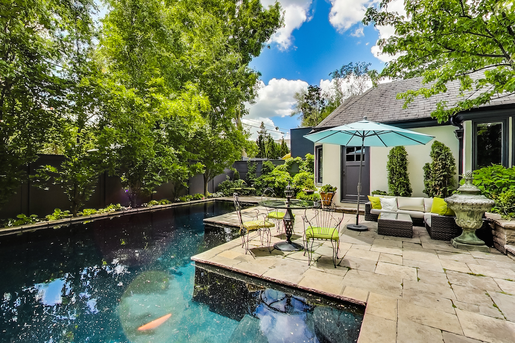 The backyard has cottage-vibes thanks to plenty of aged greenery surrounding the area. The large patio space, inground pool and pool house look great for entertaining.