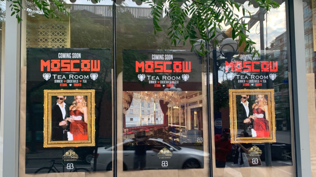 A photo of three Moscow Tea Room signs pasted along the front window of 161 Yorkville Ave.