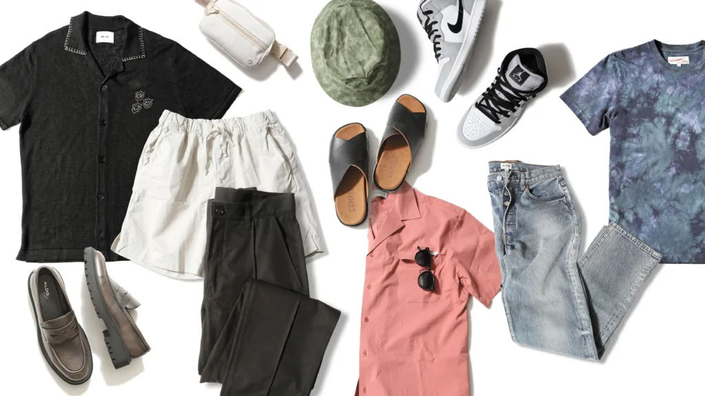 Dad fashion style picks laid out flat, featuring a black polo, white shorts, brown loafers, black pants, white crossbody, pink button-down, black sandals, green bucket hat, grey and white sneakers, light wash jeans and a tie-dye T-shirt