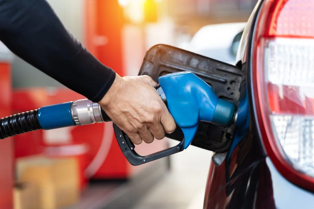 Refueling the car at a gas station fuel pump Man driver hand refilling and pumping gasoline oil the car with fuel at he refuel station