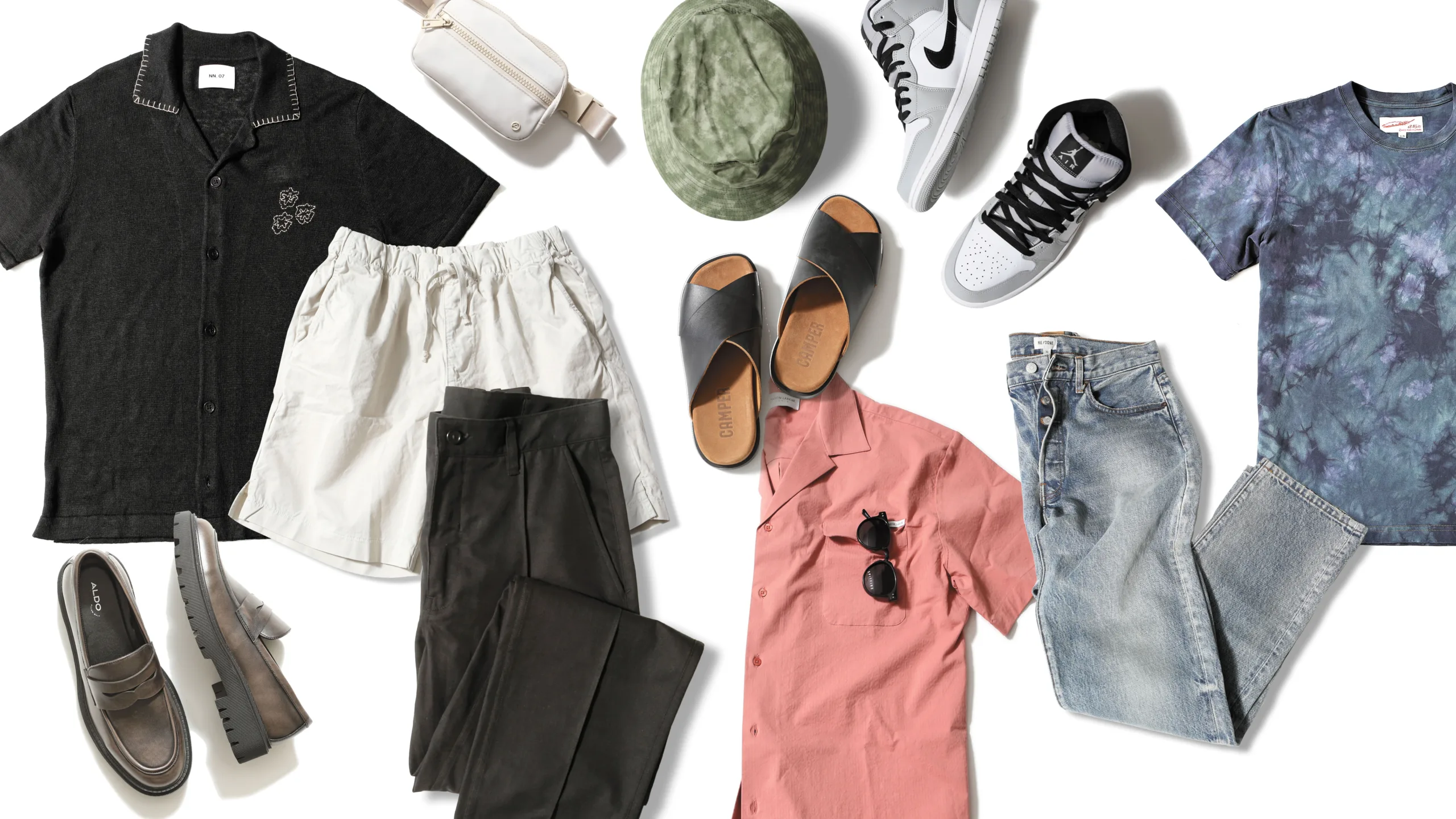 Dad fashion style picks laid out flat, featuring a black polo, white shorts, brown loafers, black pants, white crossbody, pink button-down, black sandals, green bucket hat, grey and white sneakers, light wash jeans and a tie-dye T-shirt